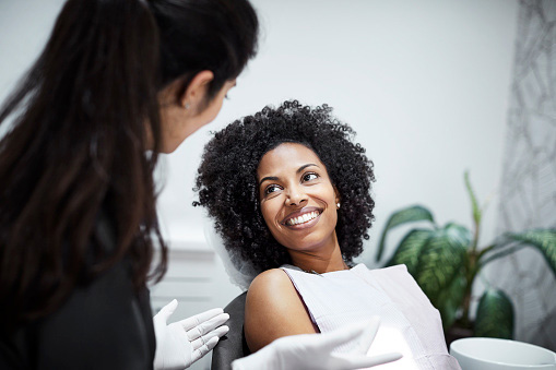  Dentist discussing tooth loss with smiling female patient at Smiles of Tulsa in Tulsa, OK 74136-8327